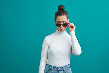 Young woman looking over her sunglasses and looking at copy space 