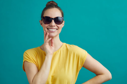 Beautiful Woman Wearing Sunglasses, In A Bright Yellow Shirt On A Contrast Background