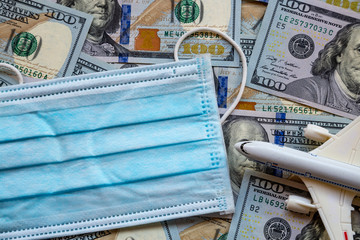 Banknotes of the United States of America and a protective mask against the virus. World economic crisis associated with coronovirus.