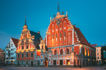 Fototapeta na wymiar Riga, Latvia. Schwabe House And House Of The Blackheads At Town Hall Square, Ancient Historical Landmark And Popular Touristic Showplace In Summer Evening. Night Illuminations