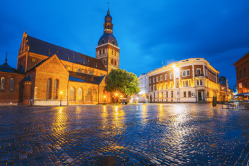 Fototapeta na wymiar Riga Latvia. Dome Square, Dome Cathedral In Evening Illumination Under Blue Sky. Medieval Monument