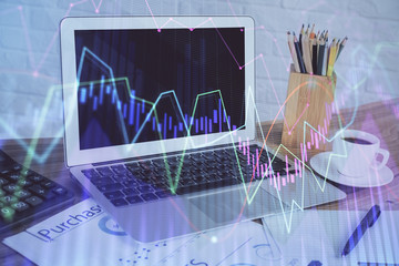 Stock market graph on background with desk and personal computer. Double exposure. Concept of financial analysis.