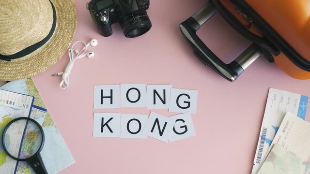 Top view hands laying on pink desk word HONG KONG