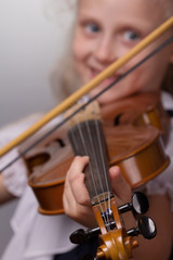 Learning musical notation and playing string instrument. Happy young student playing violin