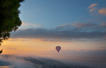 A Balloon flying with colourful sunrise sky and cloud at view point of Pamukkale, Turkey.