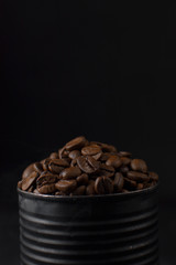 Roasted coffee beans in a black tin can, whole coffee beans in black can