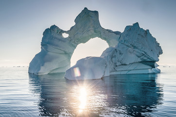 Iceberg during sunrise with backlight by sunrays. Disko Bay, Western Greenland.