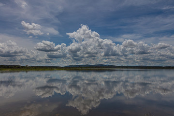 Mirror Effect on the Minneriya Wewa Lake at the Minneriya National Park , Sri Lanka. Cloudscape panorama landscape photography with reflection of the clouds on the water surface. Cumulus clouds
