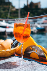 Close-up of the glass of refreshing Aperol Spritz cocktail during aperitif time in Portofino, one of the most popular picturesque coastal villages on the Italian Riviera. 