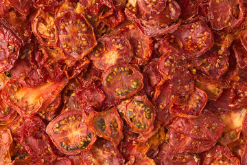 Bright texture background of ripe sun-dried tomatoes in the form of slices.