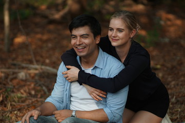 Fototapeta premium European couples, men and women Showing love to each other in the garden. During the holidays, warm and comfortable holidays in the fields and large trees. Who are planning a marriage
