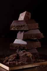 Pieces of dark chocolate on a dark background