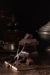 Still life with dark chocolate and tin dishes
