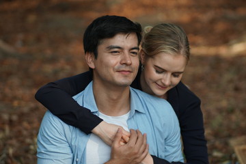 Fototapeta premium European couples, men and women Showing love to each other in the garden. During the holidays, warm and comfortable holidays in the fields and large trees. Who are planning a marriage