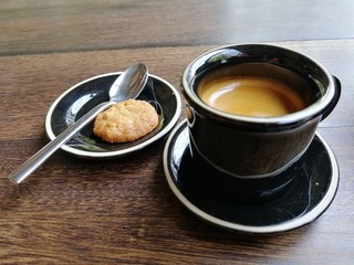 cup of coffee and cookies on wooden table