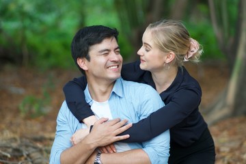 Fototapeta premium European couples, men and women Showing love to each other in the garden. During the holidays, warm and comfortable holidays in the fields and large trees. Who are planning a marriage