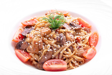 Italian pasta with cherry tomatoes, mushrooms, sesame and dill in a round plate. isolated on white