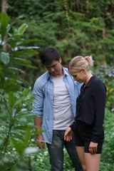 Fototapeta premium European couples, men and women Showing love to each other in the garden. During the holidays, warm and comfortable holidays in the fields and large trees. Who are planning a marriage