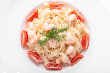 Italian pasta with cherry tomatoes, mushrooms, sesame and dill in a round plate. isolated on white