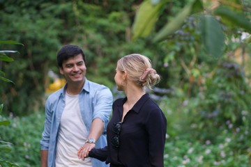 Fototapeta premium European couples, men and women Showing love to each other in the garden. During the holidays, warm and comfortable holidays in the fields and large trees. Who are planning a marriage