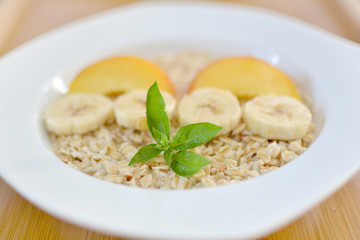 Fresh oatmeal porridge with banana, peach and honey for healthy breakfast