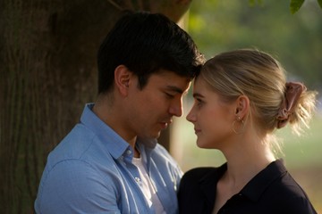 European couples, men and women  Showing love to each other in the garden.  During the holidays, warm and comfortable holidays in the fields and large trees.  Who are planning a marriage