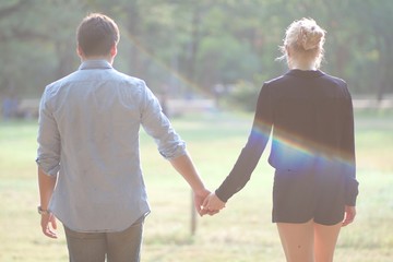 (Intended for blur and fair lighting) European couples, men and women Showing love to each other in the garden. During the holidays, warm and comfortable holidays in the fields and large trees.