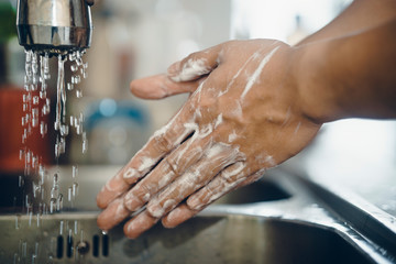Cropped shot of an unrecognizable man washing his hands  at home to prevent spreading of the coronavirus ( Covid-19)