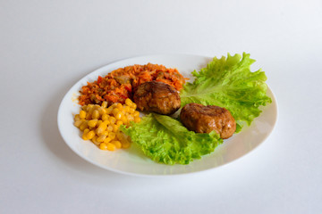 Fried chicken cutlet with potato slices served with tomato cherry and corn salad. Traditional belorussian food - roasted minced meat and potato