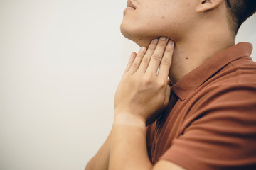 Young Asian Man in hygienic mask suffering sore throat and having flu, 2019-nCoV or coronavirus....