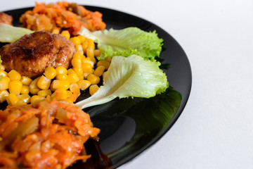 Fried chicken cutlet with potato slices served with tomato cherry and corn salad. Traditional belorussian food - roasted minced meat and potato