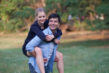 Fototapeta premium European couples, men and women Showing love to each other in the garden. During the holidays, warm and comfortable holidays in the fields and large trees. Who are planning a marriage