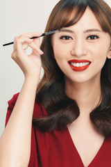 Fototapeta premium Asian young beautiful woman applying cosmetic powder brush on eyebrow, natural makeup, beauty face