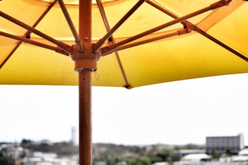 Yellow sun umbrella with wooden supports