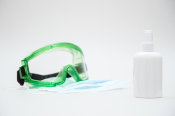 Close up. Concept. Coronavirus Pandemic COVID-19. Medical masks, sanitizer, protective glasses. White background. .