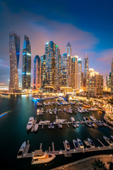 Panoramic view with modern skyscrapers and water pier of Dubai Marina at night, United Arab Emirates - obrazy, fototapety, plakaty