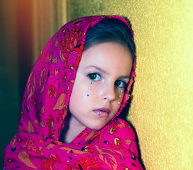 Portrait of a green-eyed girl in a pink shawl