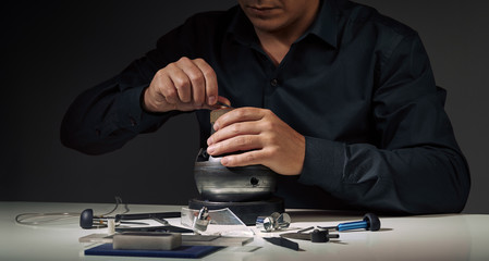 Jewelry craftsmanship, engraving. Jeweller at work. Professional engraver tools for jewelleries manufacturing on white desk. Craftsman, engraver, goldsmith workplace Wide cover banner for social media