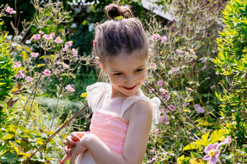 Shy little girl with mosquito bites on her face in a garden. Spring allergies in children. Health and childcare concept. Family lifestyle outdoors at summer holidays.