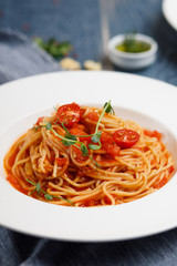 bolognese pasta with cherry tomatoes on white plate