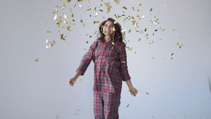 Obraz premium Beautiful woman dancing and throwing gold confetti.