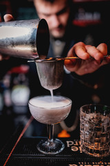  bartender pours a cocktail