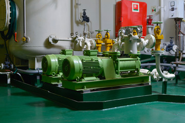 Engine room interior of a big ocean going ship with gauges, electrical motors, generators and piping