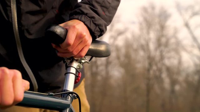 Close-up image of man adjusting bicycle at a public park, Zagreb.
