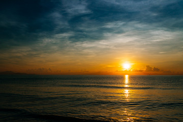 Naklejka na ściany i meble Sunrise, sunset of the sun through the clouds, tropical area near sea.