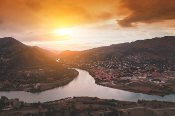 Golden sunset over the valley with rivers and mountains. Panoramic evening view of Mtskheta city and Kura with Aragvi rivers from Jvari Monastery. Georgia © vvvita