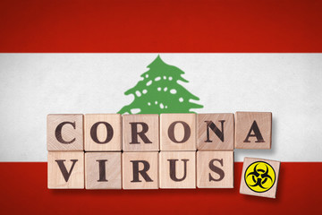 Lebanon flag background and wooden blocks with letters spelling CORONAVIRUS and quarantine symbol on it. Novel Coronavirus (2019-nCoV) concept for an outbreak occurs in Lebanon.