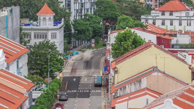 Aerial view of art deco shophouses with red roofs along Neil road in Chinatown area timelapse. Traffic on the street with intersection