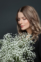 Perfect woman with white flowers on black background