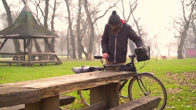 Image of young man unpacking a bicycle touring trip in a park, Croatia.